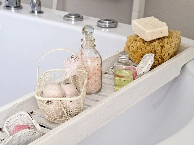 A bath tub with a basket filled with bath products.