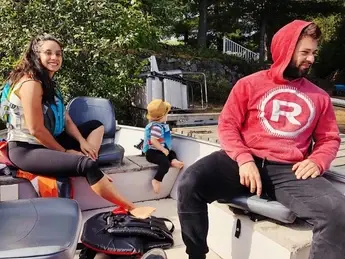 A man and woman sitting on a boat with a child.