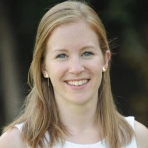 A woman in a white shirt smiling for the camera.