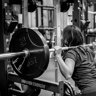 A woman doing squats in a gym.