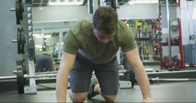 A man doing push ups in a gym.