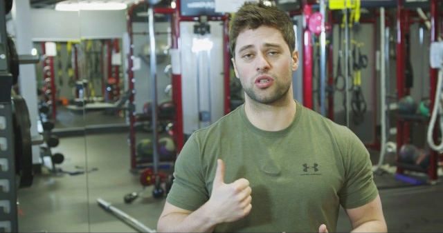 A man giving a thumbs up in a gym.