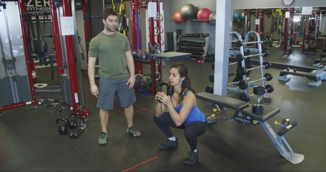 A man and a woman standing in a gym.