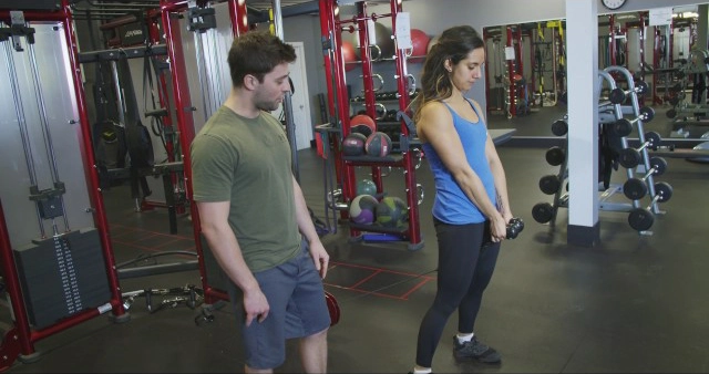 A man and a woman standing in a gym.