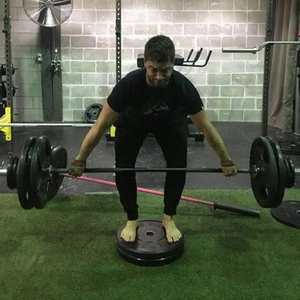 A man lifting a barbell in a gym.