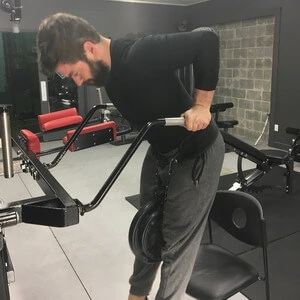 A man using a machine in a gym.